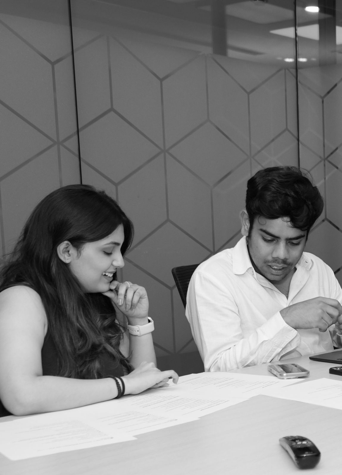 Two people reviewing printed documents in a meeting room