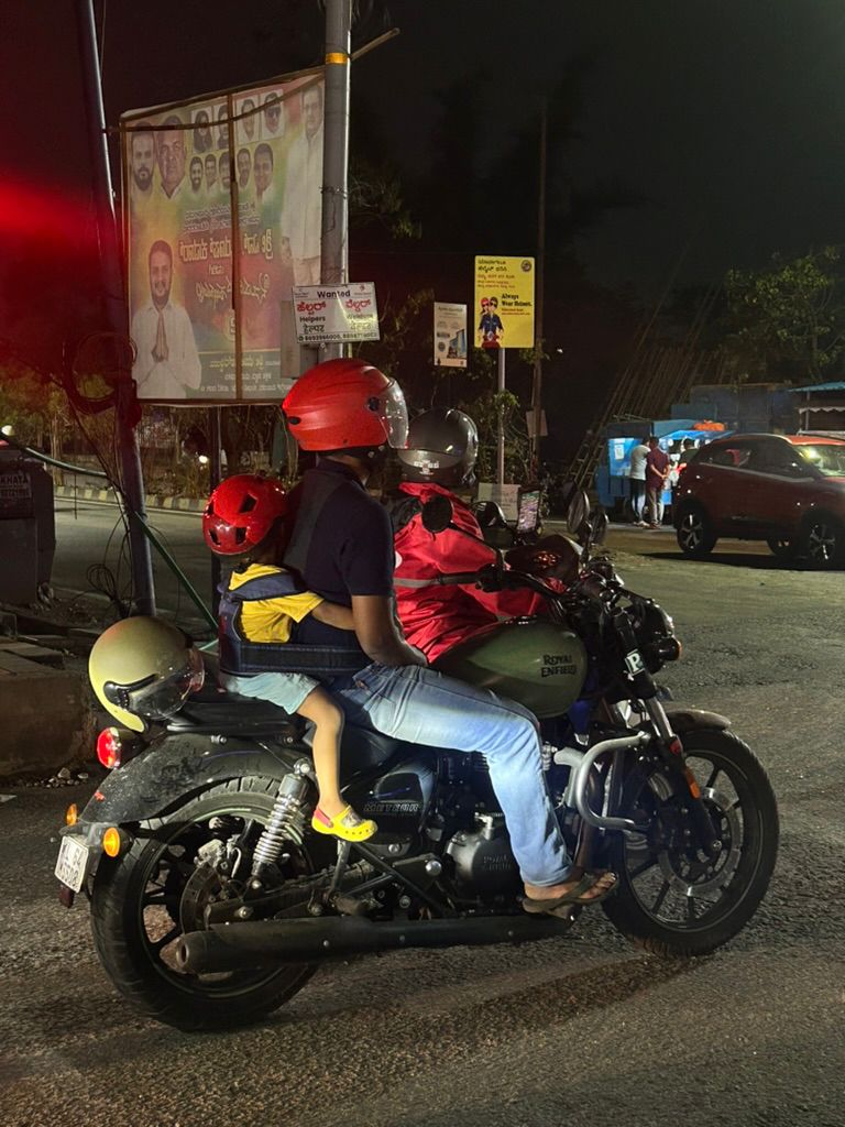 A motorcycle waiting at a roadside crossing at night