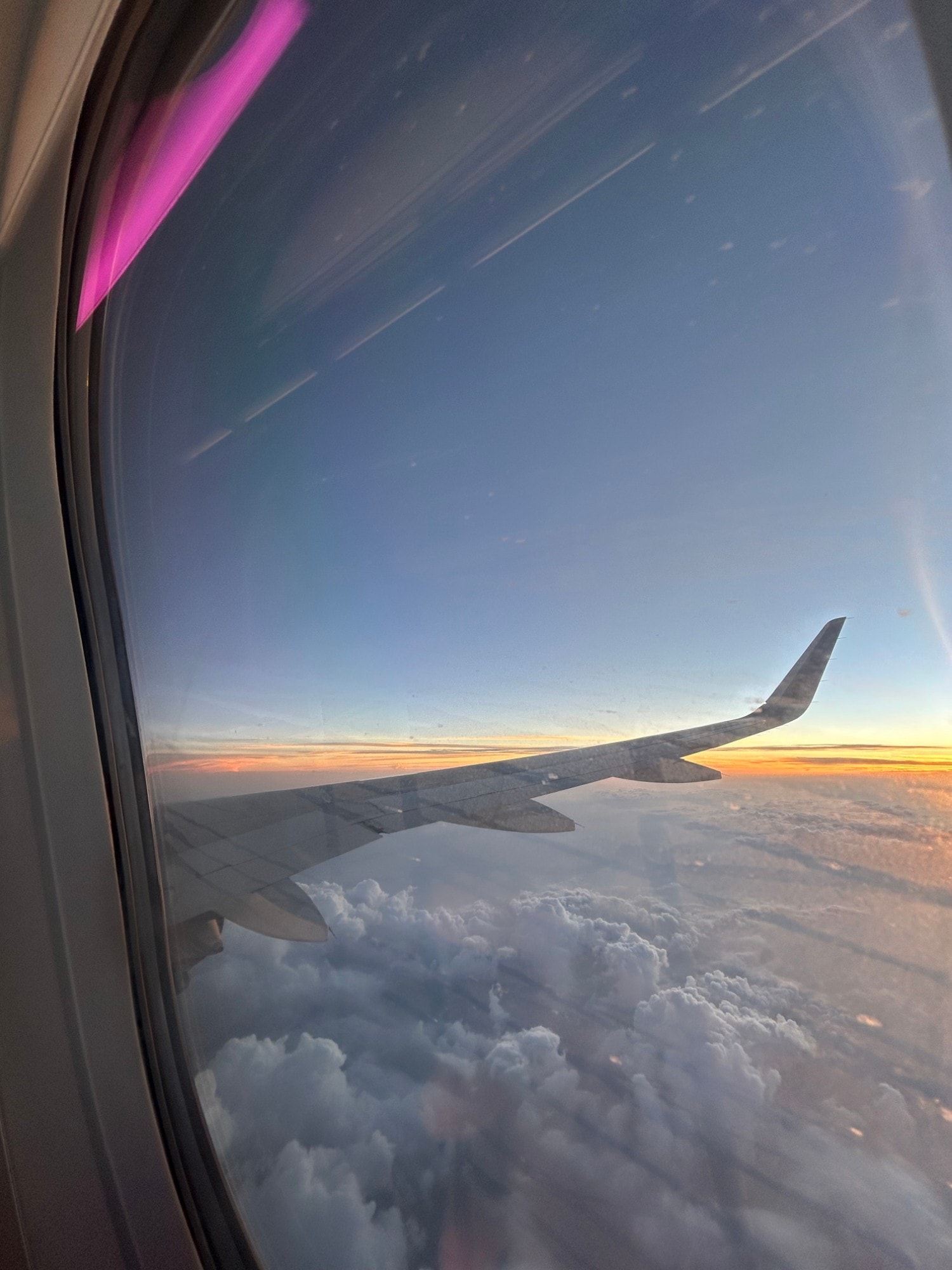 Aircraft wing above cloud at sunrise