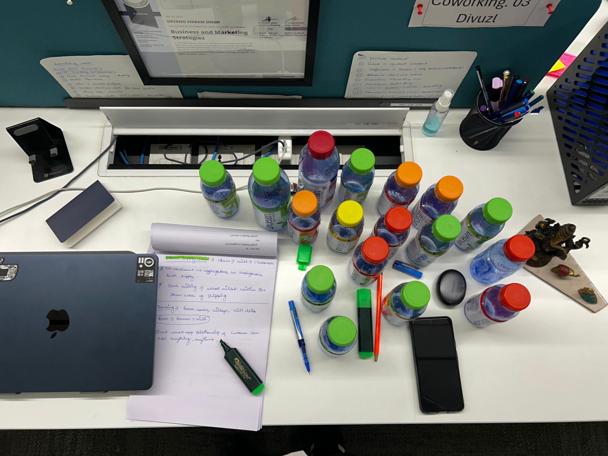 Desk laid out with product bottles, notes, and a laptop